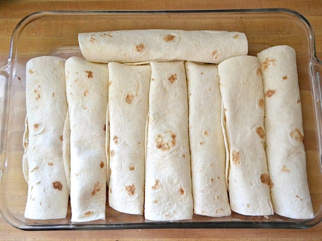 Stuffed and rolled enchiladas in baking dish 