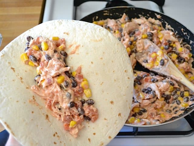 Stuffing tortilla with enchilada filling 