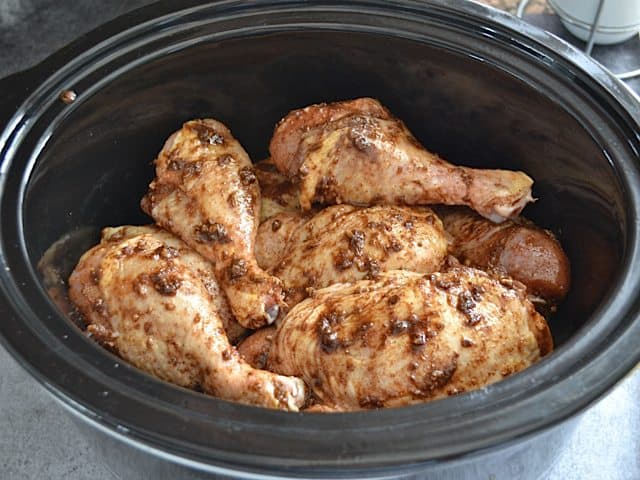 spice rubbed raw chicken added to slow cooker with onions and wine 