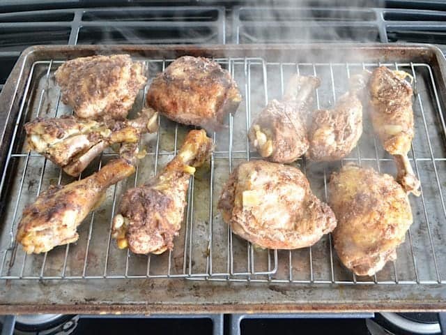 Cooked chicken pieces taken out of slow cooker and placed on baking sheet to broil so that skin gets crispy 