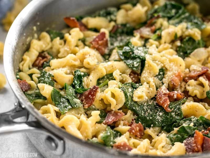 Close up of a skillet oof Bacon and Spinach Pasta with Parmesan 