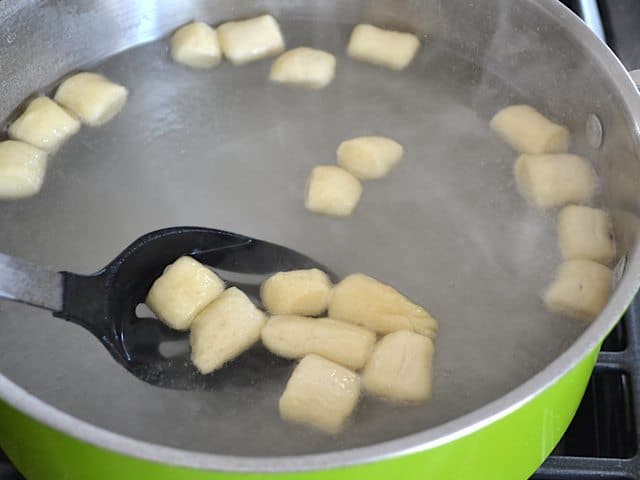Pretzel bites placed into pot of boiling water to cook 