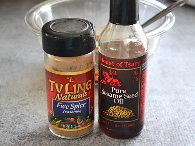 Five Spice and Sesame Oil bottles with bowl in background 