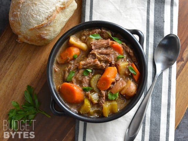 Overhead view of a bowl of Rosemary Garlic Beef Stew with bread on the side.