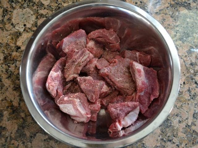 Season Stew Meat with salt and pepper in a bowl