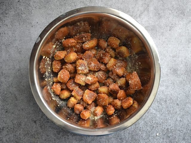 Parmesan mixture poured into mixing bowl over pretzel bites and tossed