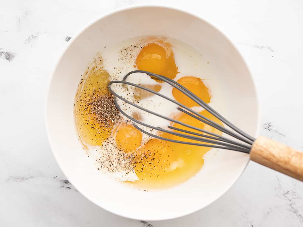 milk and eggs in a bowl with a whisk