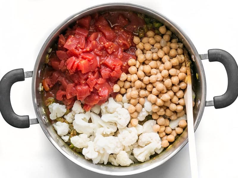 Ajouter les pois chiches, le chou-fleur et les tomates dans la marmite à soupe