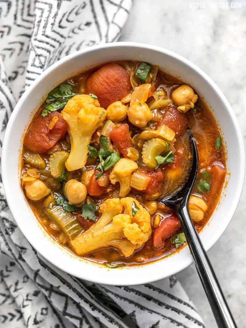 Top view of a bowl of vibrantly colored Moroccan Lentil and Vegetable Stew ready to be eaten