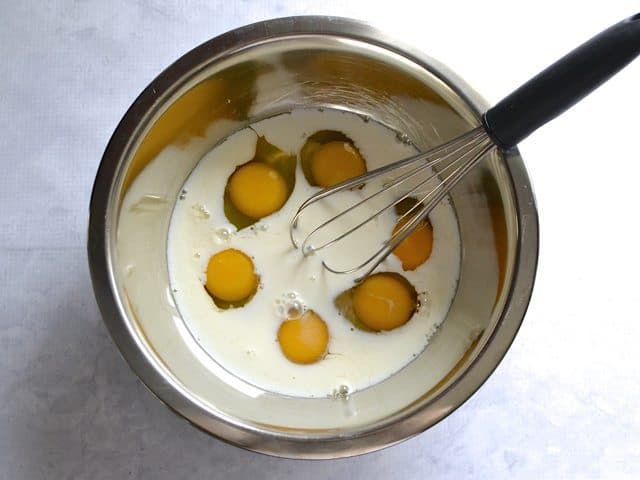 Eggs and Milk in. mixing bowl with whisk 