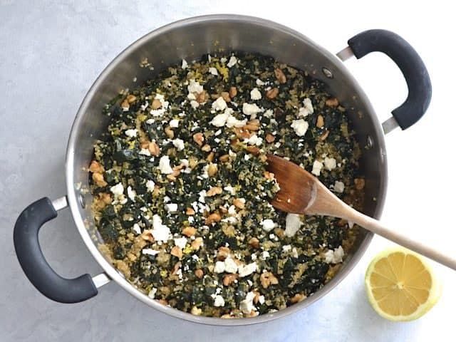 Toppings added to cooked quinoa mixture in pot 