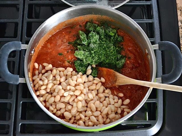White Beans and Spinach added to skillet with other ingredients 