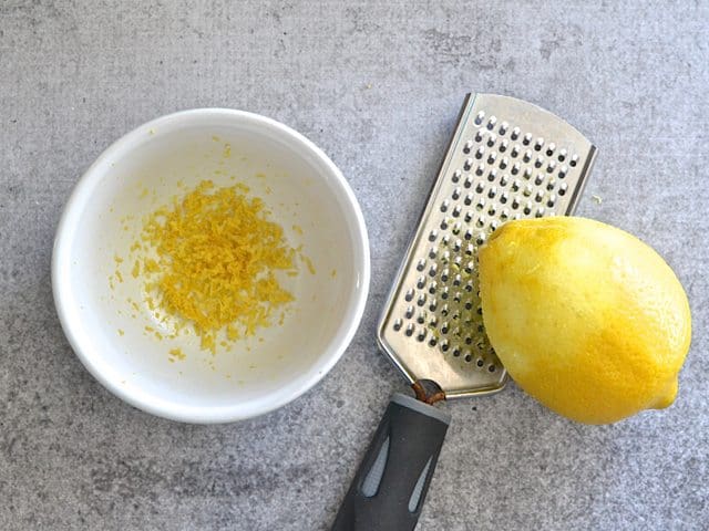 Zesting a lemon into a small bowl 