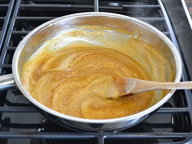 Cream added into pumpkin sauce mixture in pan 