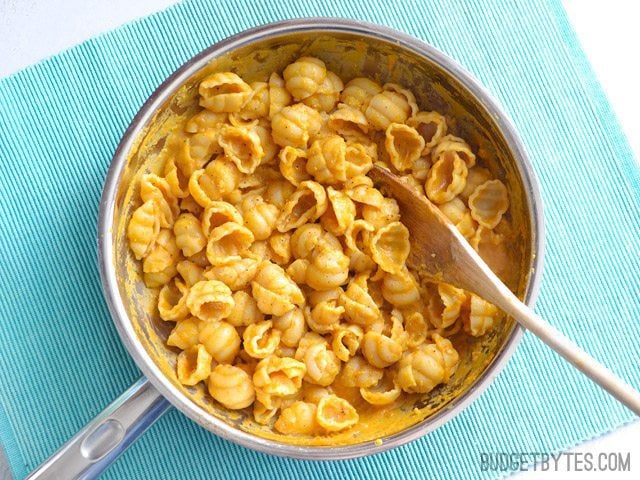 Top view of. a skillet of Pasta with Creamy Pumpkin Sauce siting on a blue place mat