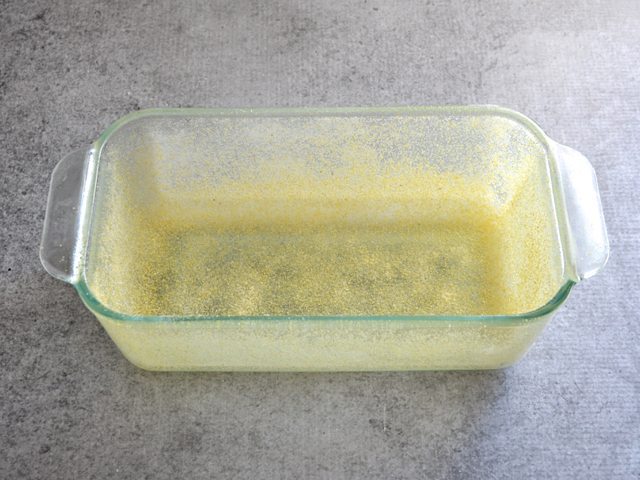 Loaf pan sprayed with non stick spray and coated with cornmeal 