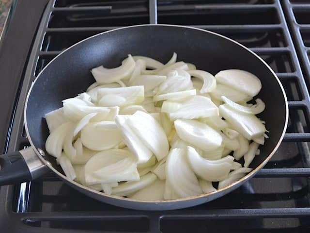 Raw Onions in skillet on stove top 
