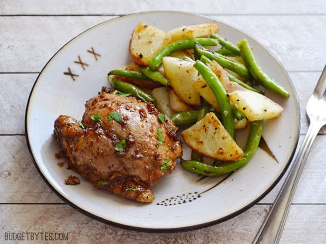 Plate of a Balsamic Chicken Thigh with potatoes and green beans on the side 