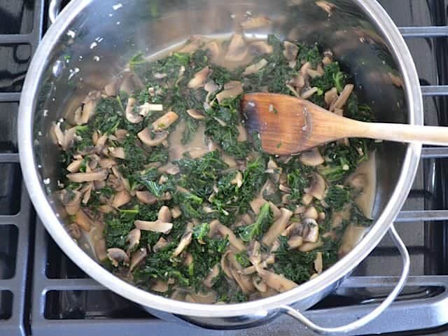 Kale added to mushrooms in pot 