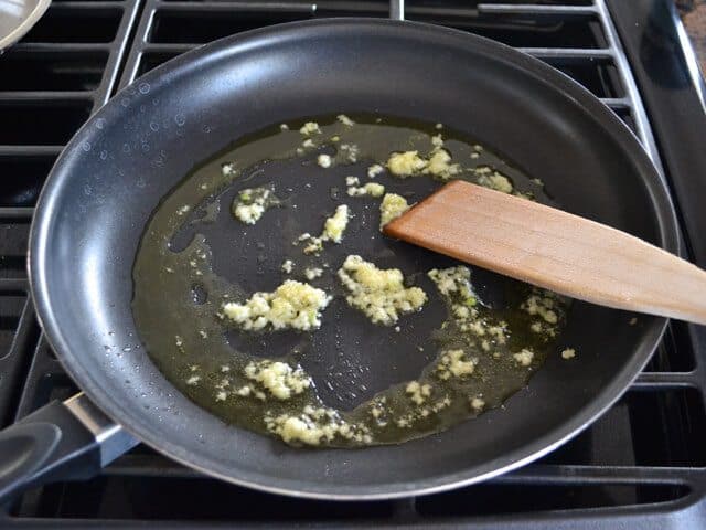 Garlic and olive oil in skillet on stove top 