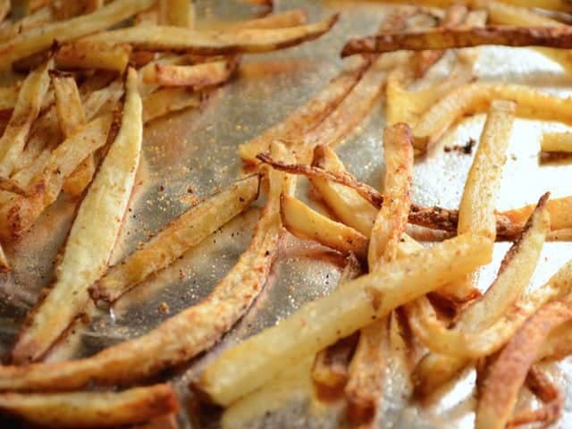 Close up of baked fries on baking sheet 