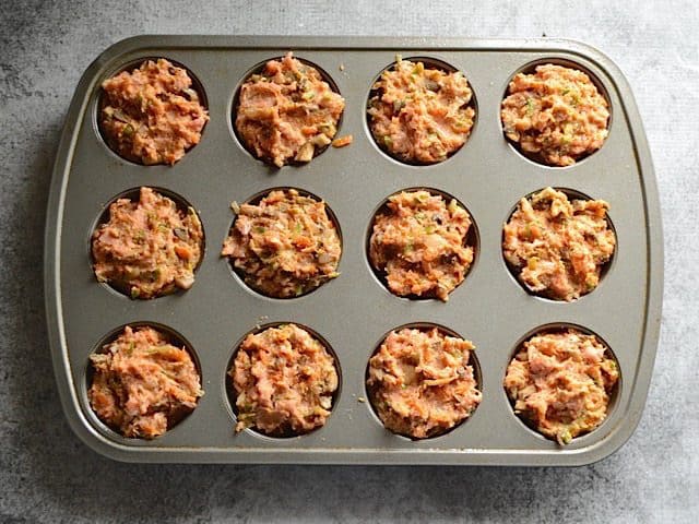 Muffin tin filled with meat and veggie meatloaf mixture 