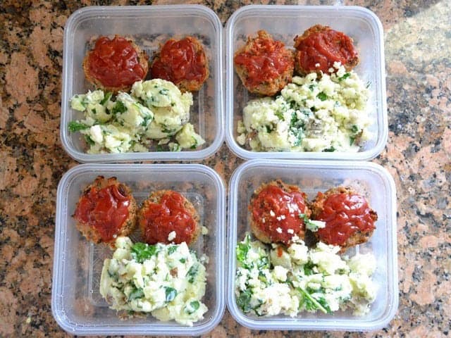 Meat loaves and potatoes portioned out into four Tupperware dishes to freeze for later 