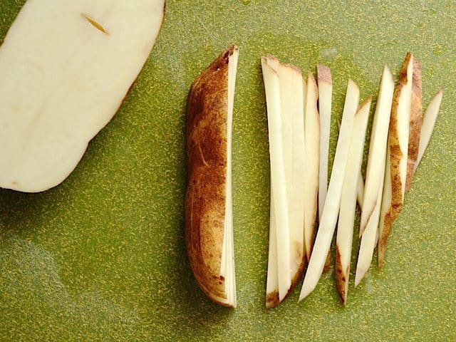 Cutting potato slices into small match stick pieces 