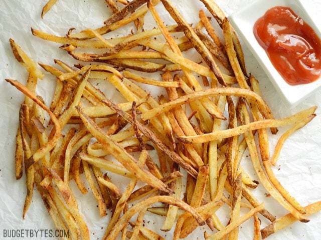 Top view of Smoky Garlic Oven Fries on a paper towel with a side of ketchup