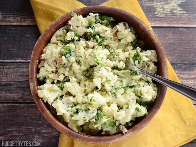 Top view of a bowl of Spinach and Feta Mashed Potatoes sitting on a yellow napkin 