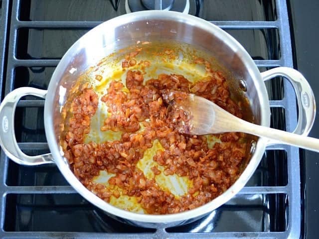 Tomato Paste and Spices added to onion in pot 