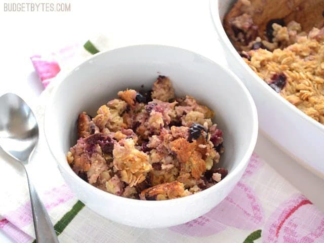 Top view of a bowl of Apple Cherry Baked Oatmeal sitting on a colorful napkin with a spoon on the side 