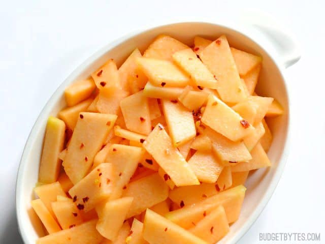 Dressing poured over cantaloupe in dish 