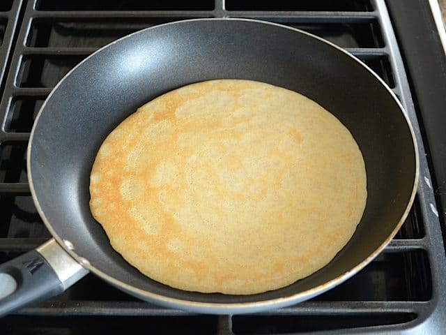 Crepe in skillet cooking other side 