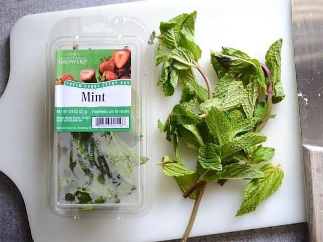 Package of Mint with some taken out to chop on cutting board 