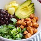 A close-up of a spicy chicken bowl with vibrant toppings.