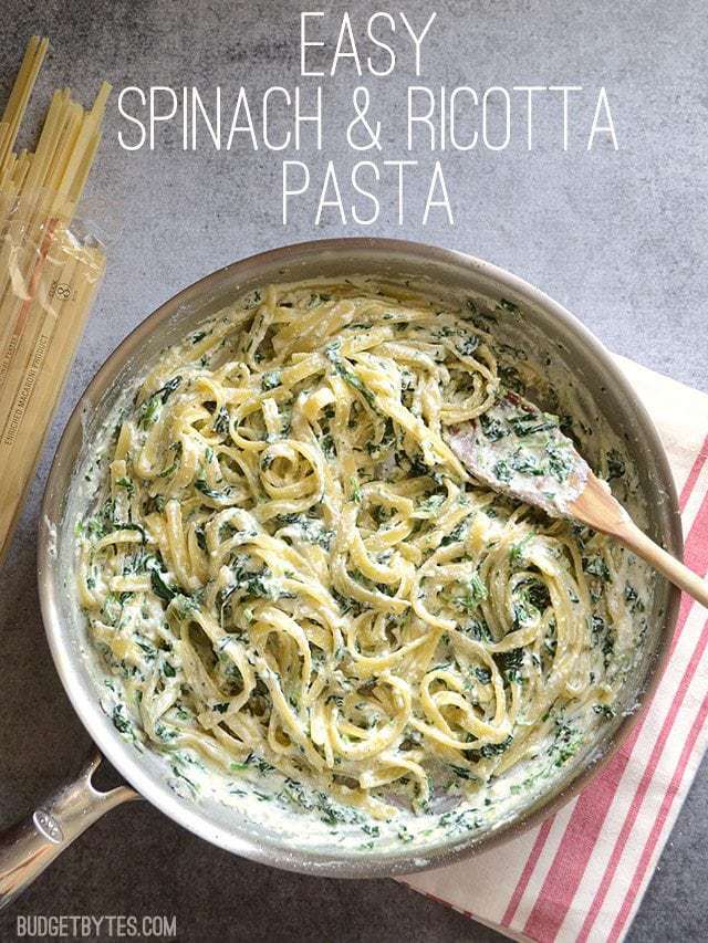 Overhead view of Spinach and Ricotta Pasta in a skillet with a wood spoon