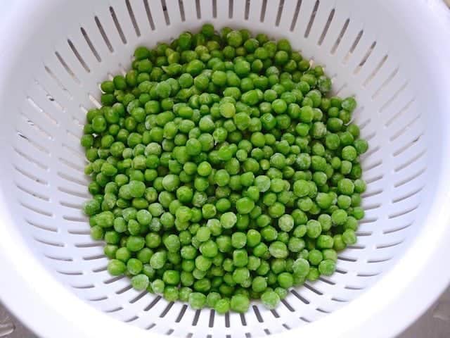 Thawing peas in strainer 