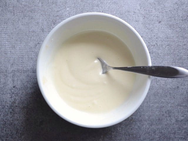 Yogurt slaw dressing in a bowl with a spoon
