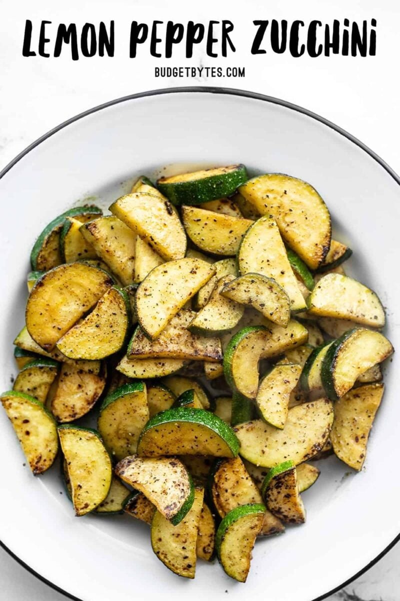 Overhead view of lemon pepper zucchini in a a bowl, title text at the top