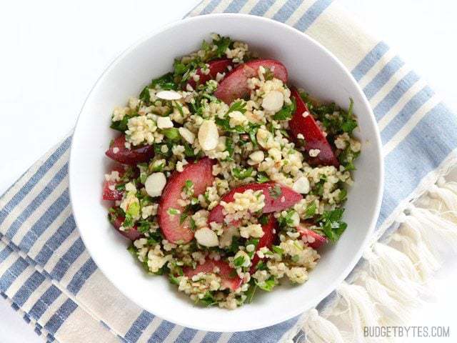 Overhead view of a bowl full of Plum Salad with Lemon Ginger Dressing