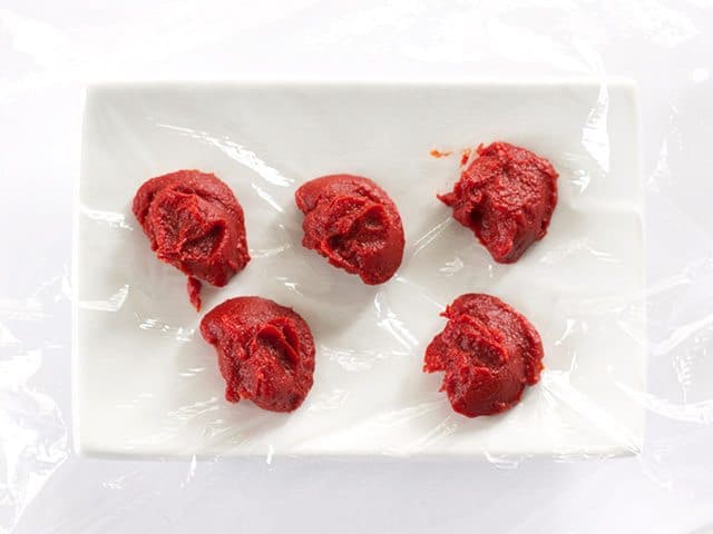 Portioned Tomato Paste on a sheet of plastic wrap 