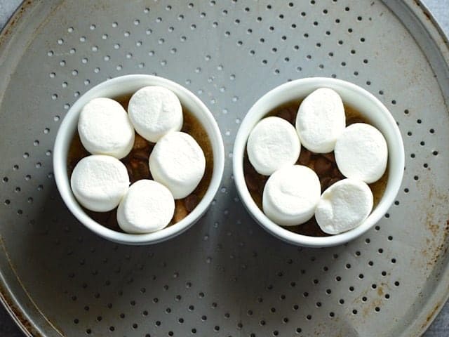Ramekins on a baking sheet, topped with marshmallows