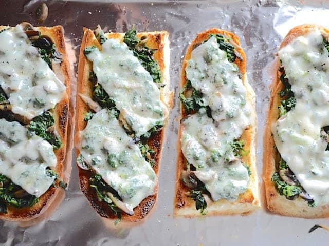 Broiled Spinach Mushroom French Bread Pizzas on a foil lined baking sheet
