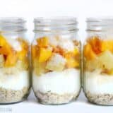 A colorful tropical yogurt parfait layered in a glass.
