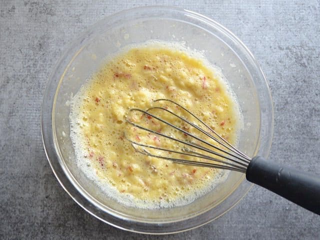 Whisked Apple Egg Mixture in a glass mixing bowl with a whisk