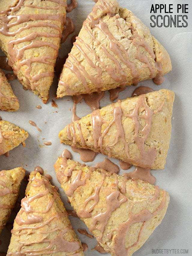 Inspired by a fresh baked apple pie, these Applie Pie Scones are flavored with cinnamon, ginger, and bits of shredded fresh apple. Budetbytes.com Overhead view of Apple Pie Scones drizzled with cinnamon glaze, title text at the top