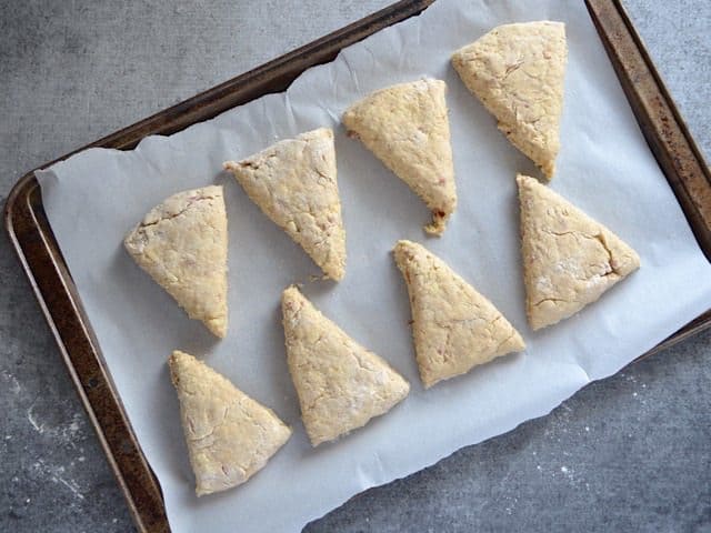 Scones on a parchment lined baking sheet, ready to bake