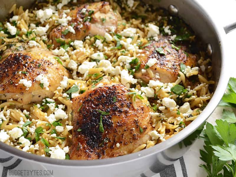 Side view of lemon pepper chicken with orzo in the skillet