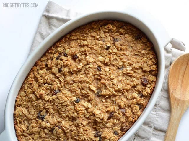 "Oatmeal Cookie Baked Oatmeal finished, in the casserole dish, wooden spoon on the side